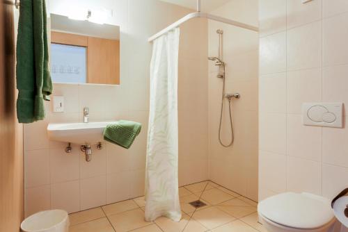 y baño con ducha, aseo y lavamanos. en Anstatthotel Luzern - self-check-in en Lucerna