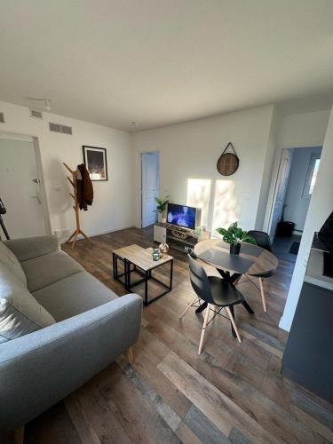 un salon avec un canapé et une table dans l'établissement Le 77! Apartment type 2, à Châlons-en-Champagne