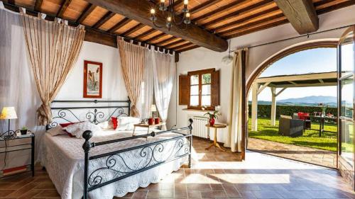 a bedroom with a bed and an open doorway at Lovely 6 bed Tuscan Farmhouse in Villamagna