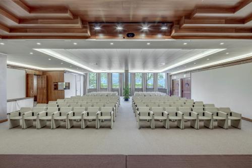an empty room with a large room with chairs at Poiano Garda Resort Hotel in Garda