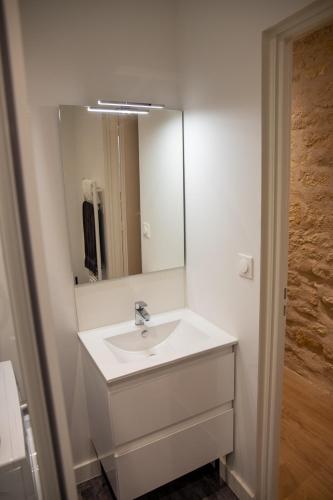 une salle de bain blanche avec un lavabo et un miroir dans l'établissement Le Banksy hyper centre avec terrasse, à Niort