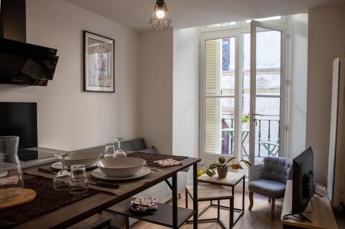 une cuisine avec une table et une salle à manger avec une fenêtre dans l'établissement Le Banksy hyper centre avec terrasse, à Niort