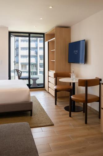 a hotel room with a bed and a table at Crisol Suites Condesa in Mexico City