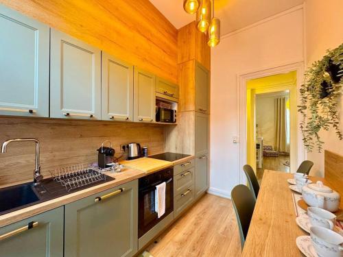 une cuisine avec une table, un évier et un comptoir dans l'établissement La suite Jade de Reims - Cathédrale, à Reims