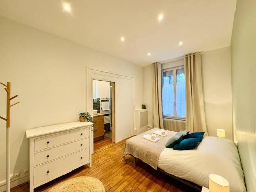 une chambre avec un lit, une commode et un miroir dans l'établissement La suite Jade de Reims - Cathédrale, à Reims