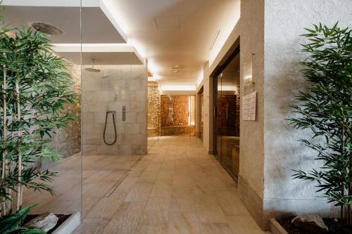 a bathroom with a shower and a walk in shower at Poiano Garda Resort Hotel in Garda