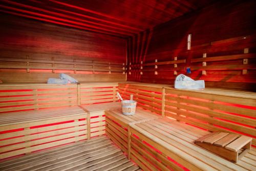 a empty sauna with wooden benches and red lighting at Poiano Garda Resort Hotel in Garda