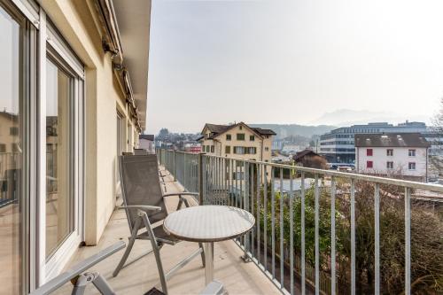 a balcony with a table and chairs and a view at Anstatthotel Luzern - contactless check-in in Lucerne