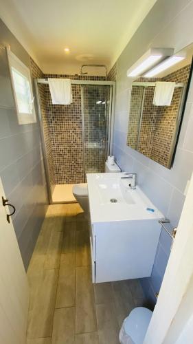 a bathroom with a white sink and a toilet at Villa Bini Kim in Binibeca
