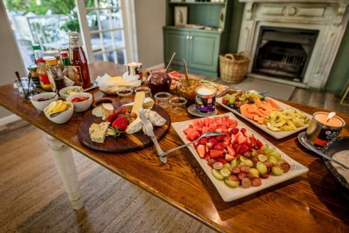 un tavolo in legno con molti piatti di cibo sopra di Corner House Residence a Franschhoek