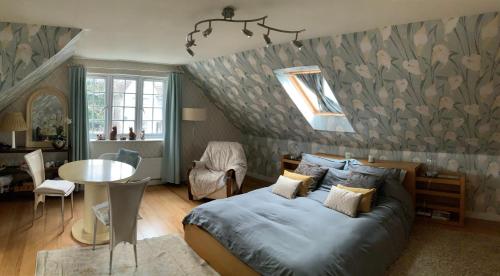 a bedroom with a bed and a table in it at Hurstbourne in Camberley