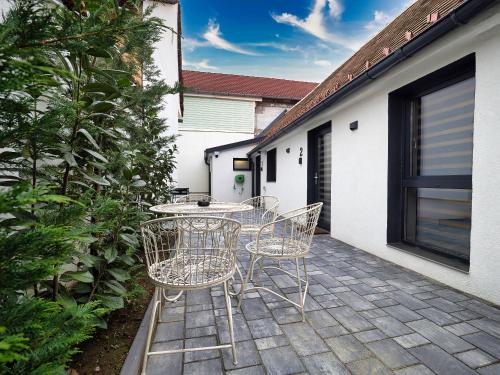 un patio con tavolo e sedie su un patio di Onyx Studios by Ben Apartments Free Private Parking a Sibiu