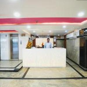 un hombre parado en un mostrador en un edificio en Hotel Kabir Palace near connaught place, en Nueva Delhi