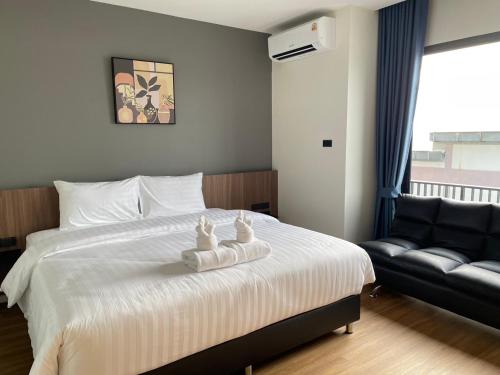 a bedroom with a bed with a chair and a couch at The Richer Ratchaburi in Ratchaburi