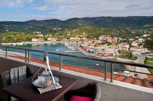 a table on a balcony with a view of a harbor at Panorama Botsaris Apartments in Sivota