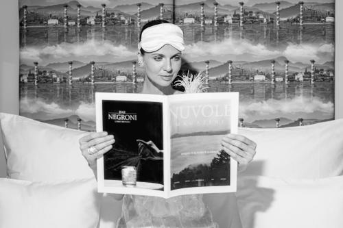 a woman is holding a book in her hands at Nuvole Garden Hotel in Brunate