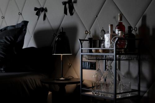 a room with a shelf with wine glasses and a lamp at The Donna Portals in Portals Nous