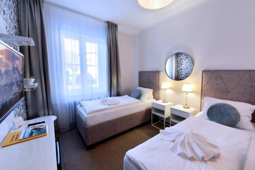 Postel nebo postele na pokoji v ubytování APLEND Hotel Lujza Major