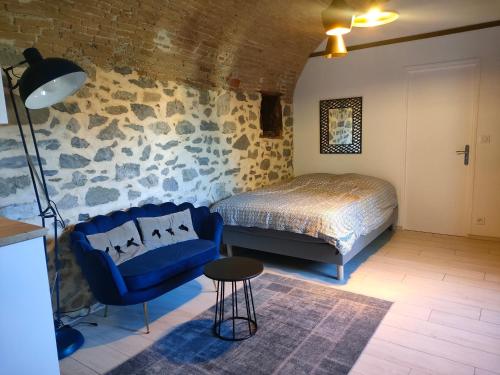 una camera con un letto, un divano blu e un tavolo di Studio voûté, atypique a Chambéry