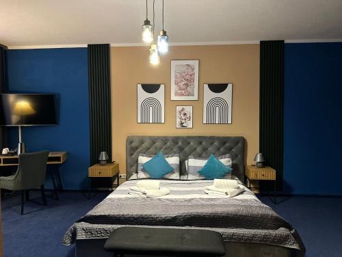 a bedroom with blue walls and a bed with blue pillows at Parkhotel Waldschlösschen in Annaberg-Buchholz