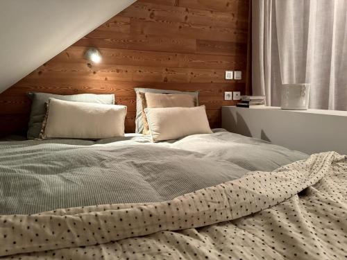 une chambre avec un grand lit avec une tête de lit en bois dans l'établissement Studio confortable Le Grand Pelvoux, à Les Claux