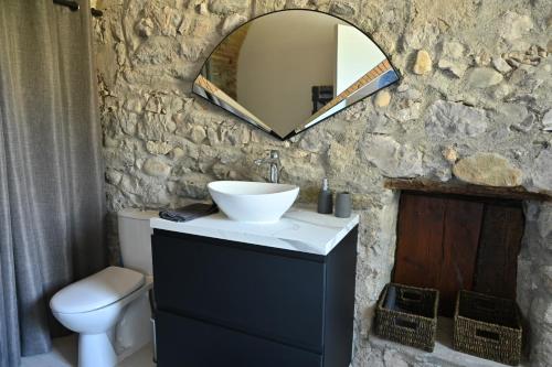 un bagno con lavandino e specchio su un muro di pietra di Studio voûté, atypique a Chambéry
