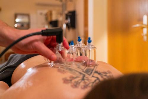 a man getting a tattoo on his back with a razor at Parkhotel Waldschlösschen in Annaberg-Buchholz