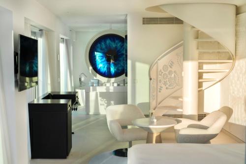 a living room with a staircase and a table and chairs at The Donna Portals in Portals Nous