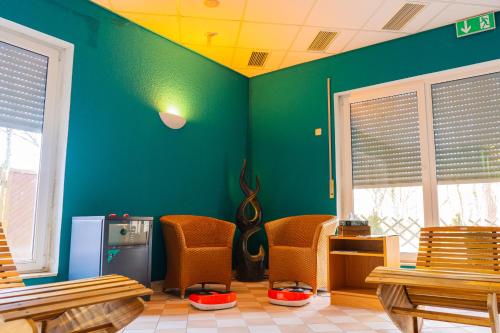 a waiting room with chairs and a green wall at Parkhotel Waldschlösschen in Annaberg-Buchholz