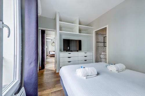 une chambre blanche avec un lit et une télévision dans l'établissement AC & 10min from Marais & Fully equipped, à Paris