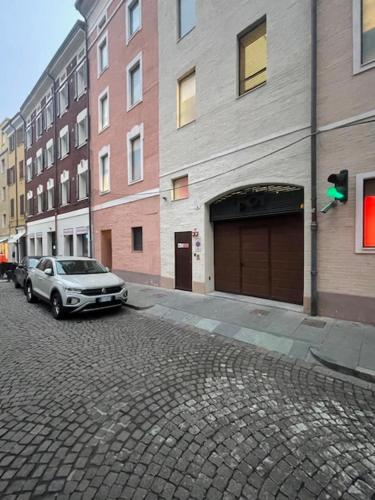 a car parked on a brick street next to buildings at Modena Relax Luxury Rent Rooms in Modena