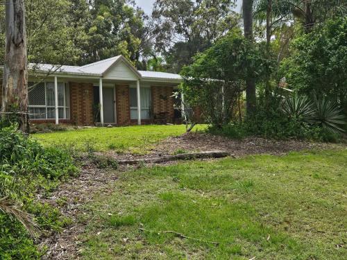 a house with a grass yard in front of it at Newly Renovated & peaceful surrounds in Eagleby