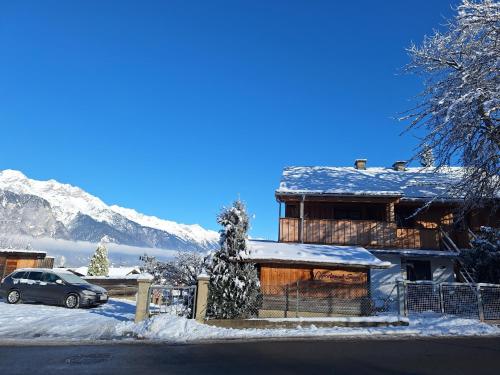 a house covered in snow with a car parked in front at Appartement Seppi in Innsbruck