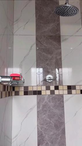 a shower with a red seat on a tile floor at Felo Guest House in Balmoral
