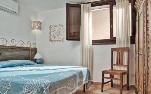 a bedroom with a bed and a chair and a window at Sea View Big Pevero in Porto Cervo