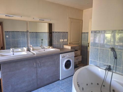 une salle de bain avec deux lavabos et une machine à laver dans l'établissement VU sur campagne, maison proche Chatellerault, à Availles en Chatellerault