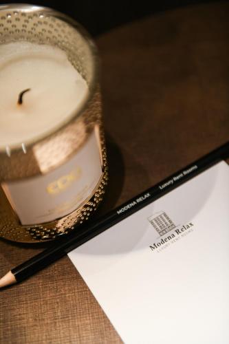 a cup and a pencil next to a piece of paper at Modena Relax Luxury Rent Rooms in Modena