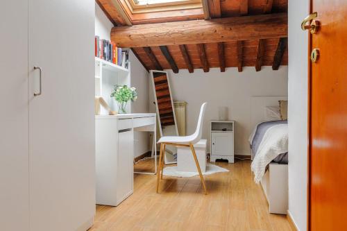 a bedroom with a desk and a bed and a chair at Mansarda nel Cuore di Pisa in Pisa