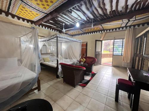 Una habitación con un dormitorio con una cama y un escritorio. en Diani Beach Luxury Retreat with 5 Bedrooms, en Diani Beach
