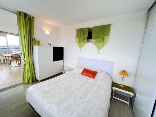 - une chambre avec un lit, un réfrigérateur et une table dans l'établissement Sol-y-days Fleurie 2, vue panoramique résidence avec piscine, à La Grande Motte