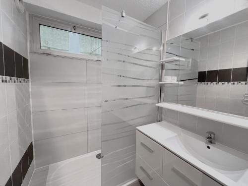 une salle de bain blanche avec un lavabo et une douche dans l'établissement Sol-y-days Fleurie 2, vue panoramique résidence avec piscine, à La Grande Motte