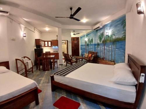 a bedroom with two beds and a dining room at Sol Y Mar - Unawatuna in Galle