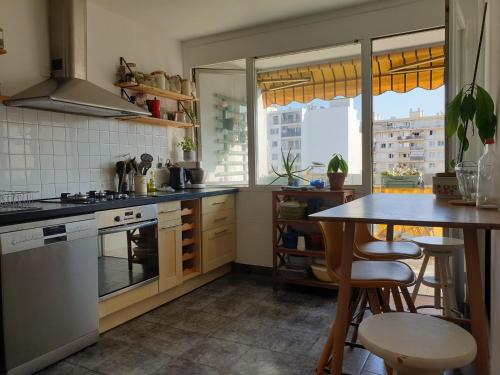 une cuisine avec un comptoir et une table avec des chaises dans l'établissement Bel appartement lumineux T3 Terrasse, à Nice