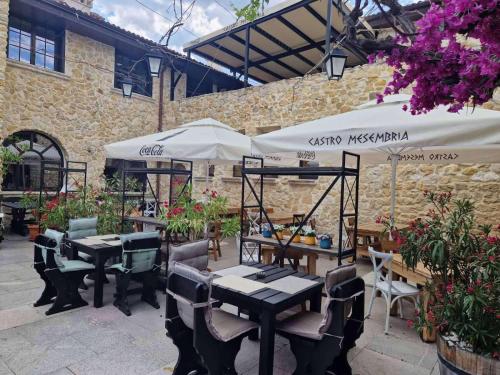 a patio with tables and chairs and umbrellas at Castro Mesembria Boutique Hotel in Nesebar