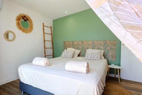 un dormitorio con una cama con sábanas blancas en L'écrin salé, en Étang-Salé