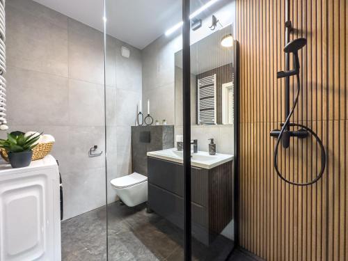 Un baño con ducha, inodoro y lavabo. en Nowoczesny Apartament Pychowicka 3B, en Cracovia