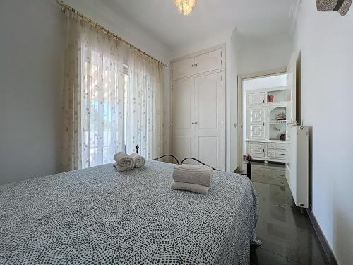 a white bedroom with a bed with towels on it at Pineview Terrace and Pool in Olhão