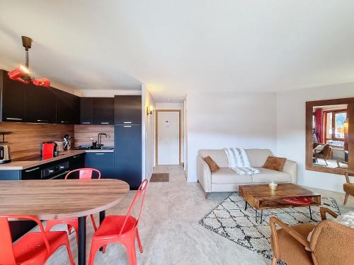Il comprend une cuisine et un salon avec une table. dans l'établissement Bouillandire-appartement- 7pers- Proche Centre, aux Gets