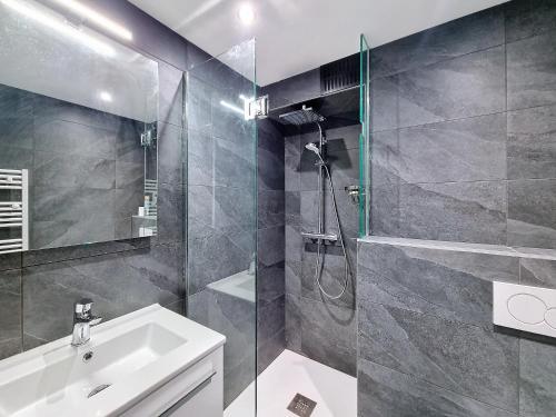 une salle de bain avec une douche, un lavabo et un miroir dans l'établissement Bouillandire-appartement- 7pers- Proche Centre, aux Gets