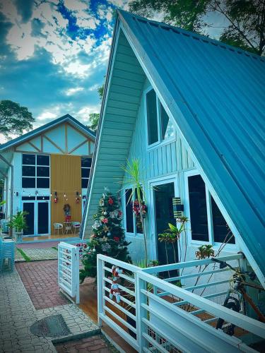 a house with a christmas tree on the porch at Cozy A Cabin Escape Your Tranquil Getaway Awaits in Hermosa